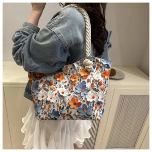 Detail of floral tote bag featuring 3D flower appliques and thick cotton rope handles