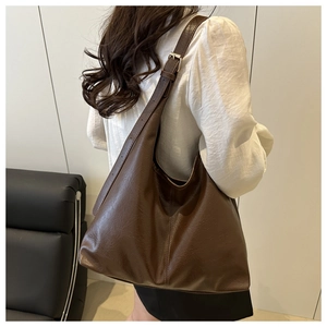 Detail of dark brown hobo bag with adjustable wide strap and vintage leather texture