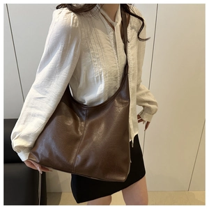 Model wearing dark brown large capacity faux leather hobo bag with vintage texture