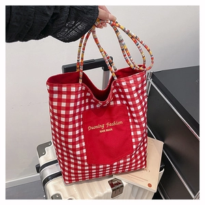 Detail of red and white plaid canvas tote bag with contrast pocket and braided rope handles
