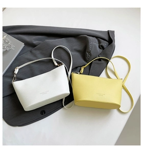 Détail de sacs seaux blancs et jaunes avec texture cuir grainé et boucles dorées
