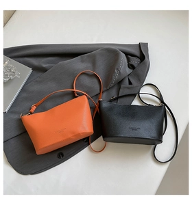 Détail de la texture grainée de cuir sur des sacs seaux orange et noirs