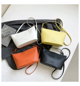 Vue à plat de sacs seaux en cuir minimalistes en blanc, jaune, orange et noir