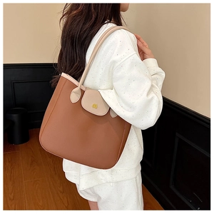 Détail du sac cabas bicolore avec fermoir fleuri doré et texture en cuir grainé