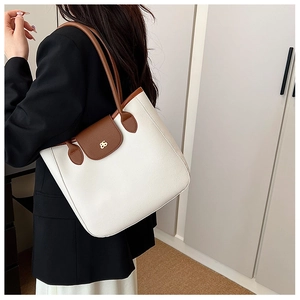 Détail du sac cabas blanc grainé avec anses en cuir marron et logo doré chic