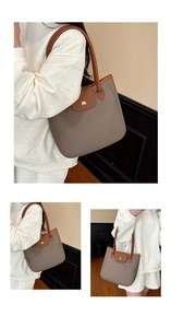 Détail du cabas en cuir taupe avec logo BS doré et poignées en cuir marron contrastées