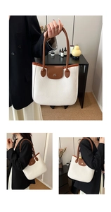 Détail d'un sac cabas blanc texturé avec anses marron et logo métallique doré