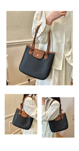 Détail du sac cabas noir et marron avec texture cuir et accents de logo dorés
