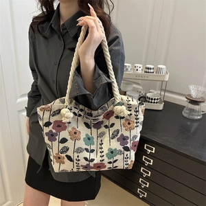 Chic floral canvas tote bag with woven rope handles shown in a lifestyle setting