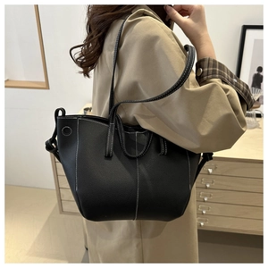Close-up of black leather tote bag with stylish white contrast stitching details