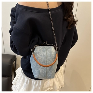 Blue denim mini crossbody bag with gold clasp and chain strap shown on model