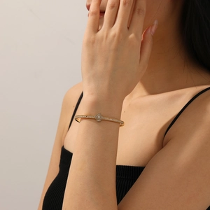 Elegant gold flower bracelet with mother of pearl and diamonds shown on a wrist