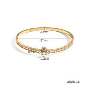 Elegant gold open bangle with white camellia flower pendant and zircon inlay accents