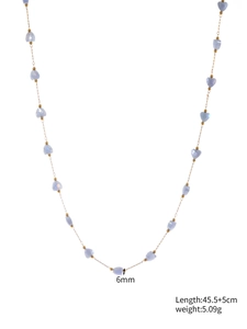 Detail view of heart-shaped blue crystal beads on a gold chain with length specifications