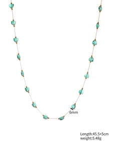 Detail of 6mm green heart crystal beads and golden metal spacers on a slim chain