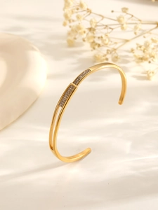 Nahaufnahme eines zweischichtigen 18k vergoldeten Armreifs mit Zirkonia-Inlays