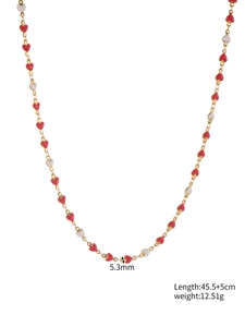 Detail view showing 5.3mm red and white enamel heart charms on a gold chain necklace