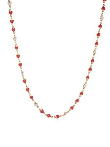 Detail view of gold chain necklace with red and white heart enamel charms on white background