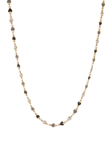 Detail of gold necklace featuring black, white and grey enamel heart-shaped pendants