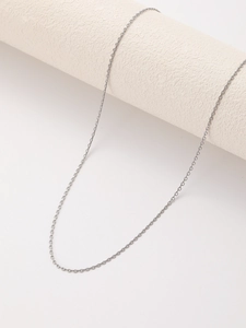 Close-up of minimalist silver stainless steel O-chain necklace on a white display stand