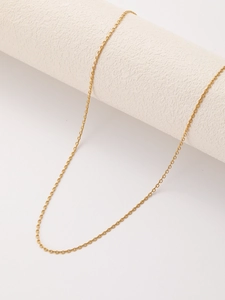 Detailed macro view of a gold-plated stainless steel cable chain over a white stone prop