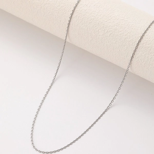 Minimalist silver stainless steel O-chain necklace with fringe accents shown on props