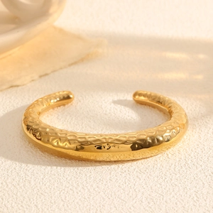 Detailed close-up of a gold-plated C-shape open bangle with hammered honeycomb texture