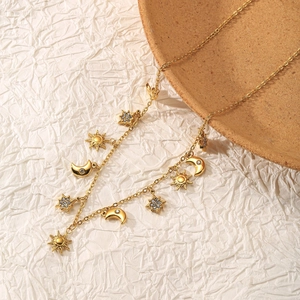 Détail du collier doré lune et soleil orné de breloques scintillantes en zircon