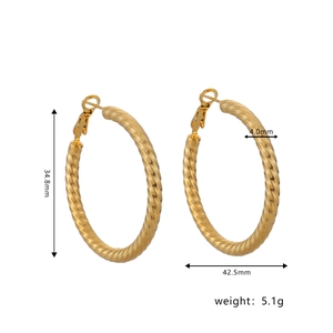 Detailed view of large gold twisted hoop earrings showing specific height and width measurements