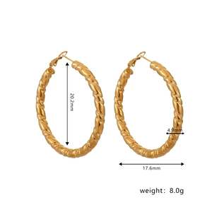 Macro detail of golden twist hoop earrings with spiral texture and size dimensions