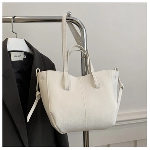 Detail of white lychee texture tote bag featuring side knot design and detachable strap