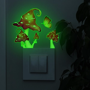 Glow-in-the-dark mushroom and butterfly wall decals glowing bright green over a light switch