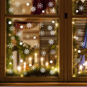 Detail of white snowflake window clings on glass with warm festive background lights