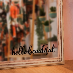Close-up of 'hello beautiful' cursive vinyl decal applied to a vintage wooden framed mirror