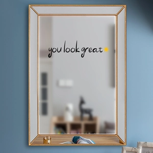Close-up of 'You Look Great' wall decal with sun design on a mirror in a stylish room