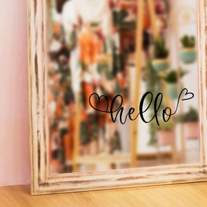 Detail showing vintage wood frame wall mirror with black hello calligraphy sticker