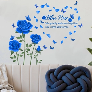 Blue rose and butterfly wall decals with English typography above a beige sofa