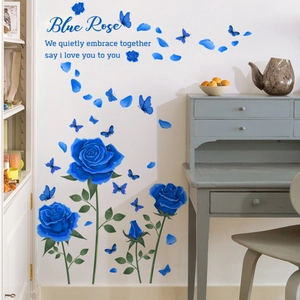 Detail of blue rose wall decals and fluttering butterflies on a white living room wall