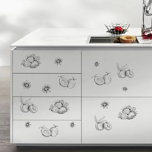 Detailed view of hand-drawn fruit wall stickers on minimalist white kitchen cabinets
