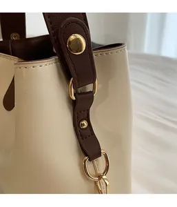 Close-up of premium gold-toned metal buckles and rivets on a retro bucket handbag