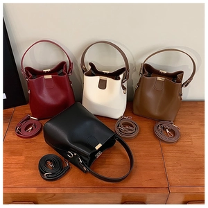 Macro view of bucket bags in four colors with matching leather crossbody straps