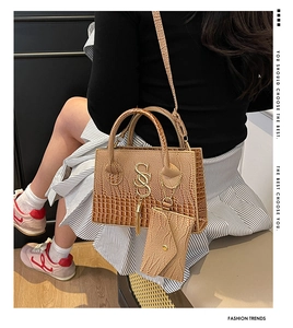 Detail of brown crocodile pattern tote with gold SS hardware and matching envelope pouch