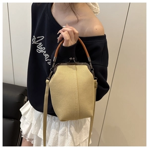Detail of vintage canvas crossbody bag with metal frame closure and leather handle