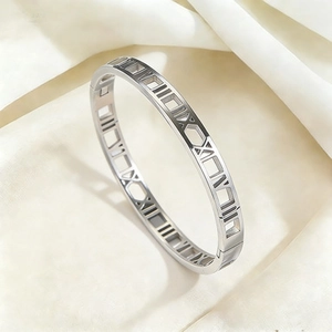 Silver stainless steel bangle featuring hollow Roman numerals with a side hinge closure