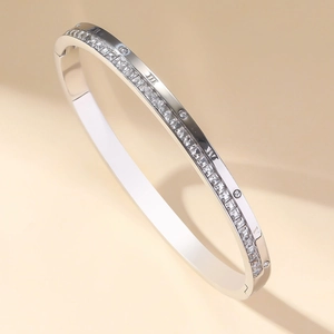 Polished titanium steel bangle with Roman numerals and single row of square zirconias
