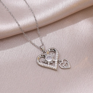 Collier minimaliste à double cœur en zircon sur fond élégant de satin de soie champagne