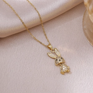 Chic gold bunny pendant necklace with sparkling rhinestones on elegant silk background