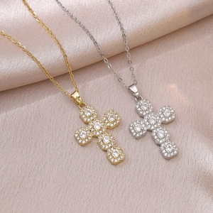 Klassieke kruisketting in goud en zilver met kristallen op een satijnen achtergrond