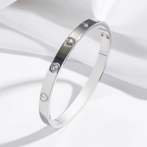Bracelet jonc en acier poli avec cœurs gravés et pierres blanches sur soie