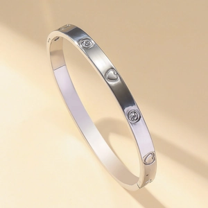 Bracelet jonc cœur en acier inoxydable argenté avec cristaux sur fond beige